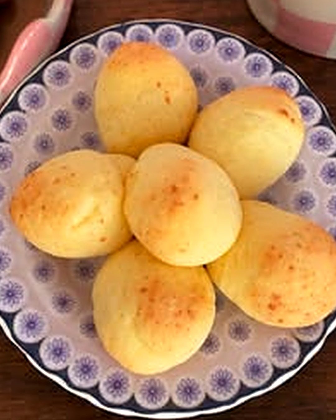 Pães de queijo em prato de louça pintada com flores